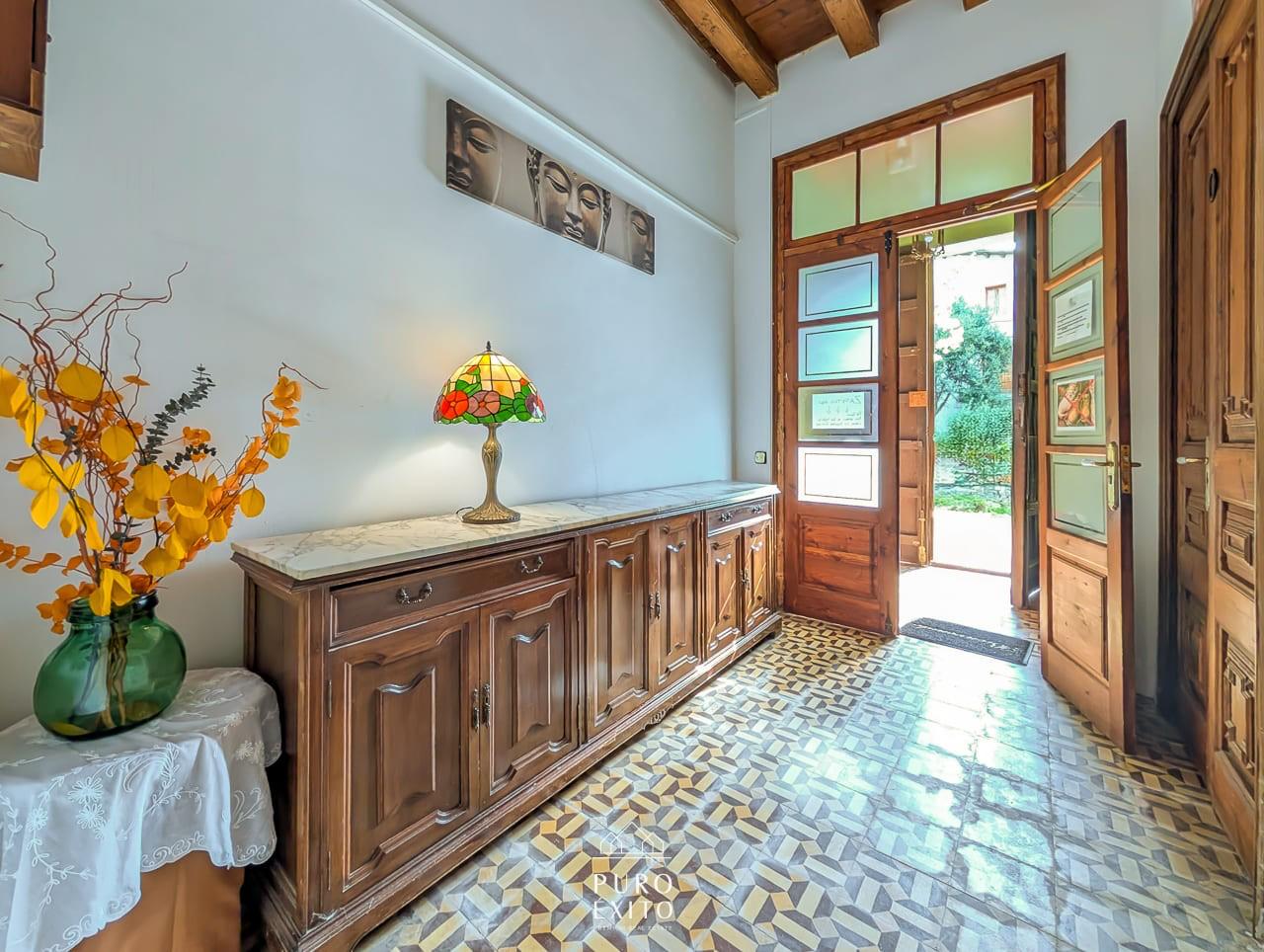 The entrance hall, with a patterned tiled floor and glazed double doors standing open to the garden.